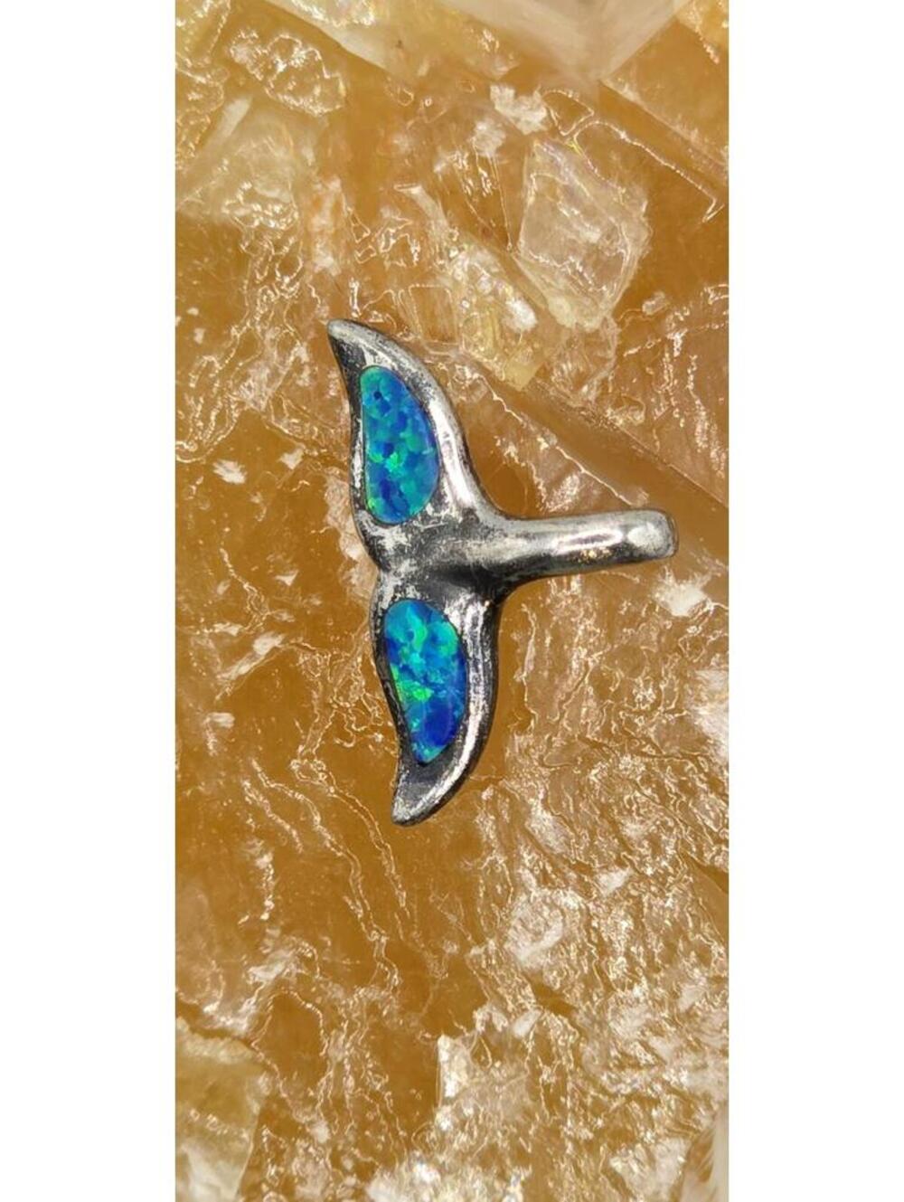 This is a charming whale tail-shaped pendant crafted from sterling silver.